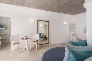 een witte woonkamer met een tafel en stoelen bij Alta Mare by Andronis in Oia