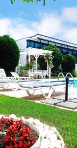 a patio with a pool and a table and flowers at MAISONETTES in Royal Bay Residence and SPA in Sveti Vlas