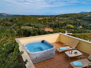 a hot tub on the balcony of a house at Villa Erontas - private heated jacuzzi in Makhairoí