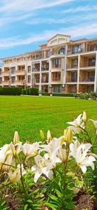 a large building with white flowers in front of it at MAISONETTES in Royal Bay Residence and SPA in Sveti Vlas