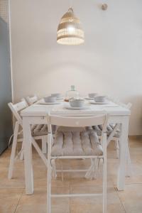 a white dining room table with chairs and a light fixture at Wave & Chill -The House- in Cotillo