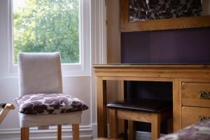 una silla junto a un escritorio y una ventana en Nama-Stay Harrogate, en Harrogate