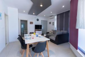 a dining room and living room with a table and chairs at Apartman Dora in Podstrana