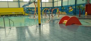 an indoor swimming pool with a water park at Golden Palm Resort Sherwood 6 Berth Club Tropicana Chapel St Leonards in Skegness