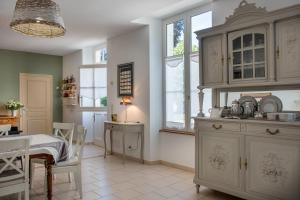 a kitchen with white cabinets and a table in it at Le Clos Richelieu in Amboise +19 photos