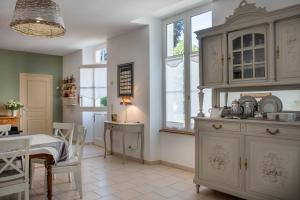 a kitchen with white cabinets and a table in it at Le Clos Richelieu in Amboise