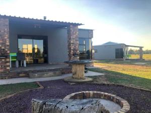a house with a fire pit in the yard at Rondebosch Eco Cottages in Middelburg