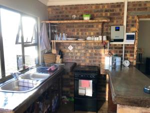 a kitchen with a sink and a stove top oven at Rondebosch Eco Cottages in Middelburg