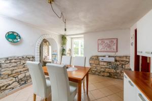 a kitchen and dining room with a table and chairs at Holiday house Ruba in Marčana