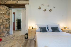 a bedroom with a white bed and a stone wall at Holiday house Ruba in Marčana