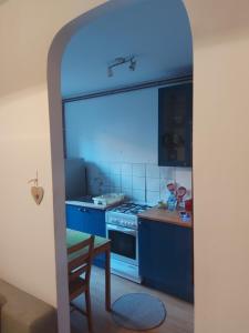 a kitchen with blue cabinets and a table and a chair at Kamienica Toruń in Toruń