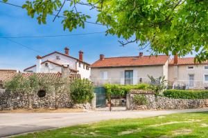 a large white house with a stone fence at Holiday house Ruba in Marčana