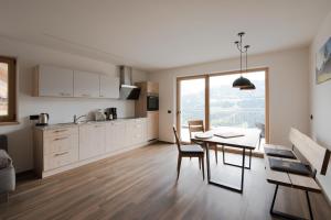 a kitchen and dining room with a table and chairs at Jaufnerhof in Mareta