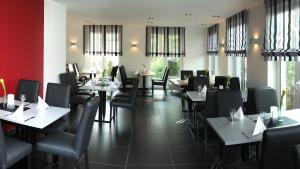 a dining room with tables and chairs and windows at Hotel Zur Post in Trier