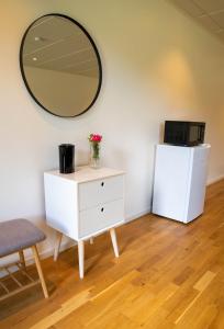 a dressing table with a mirror and a dresser with a refrigerator at Kungälv-Kode Golf Club Bed & Breakfast in Kode