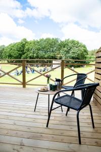 a patio with a table and a chair on a deck at Kungälv-Kode Golf Club Bed & Breakfast in Kode