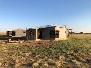 a house with a tin roof on a field at Rondebosch Eco Cottages in Middelburg