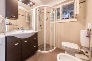 a bathroom with a shower and a toilet and a sink at Residence La Mignon Oleandri in Torri del Benaco +22 photos