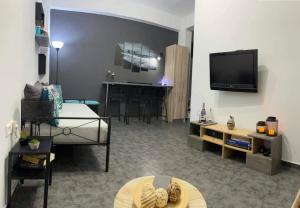 a living room with a television and a room with a table at Sabbia Calda 8 by Comfortbnb in Perissa