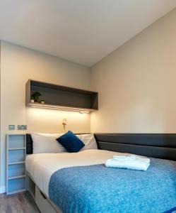 a bedroom with a large bed with a blue blanket at The Westwood Apartments in Galway