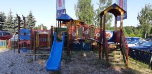 une aire de jeux avec un toboggan bleu et un toboggan bleu dans l'établissement Glamp Natura Kryspinów, à Cholerzyn