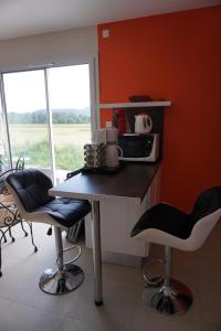 a kitchen with a table and two chairs and a microwave at Chez Brigitte, un séjour en Haute-Loire in Saint-Germain-Laprade