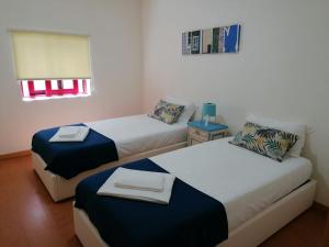 ヴィラ・ノヴァ・デ・ガイアにあるPortus Ribeira Houseのベッド2台、テーブル、窓が備わる客室です。