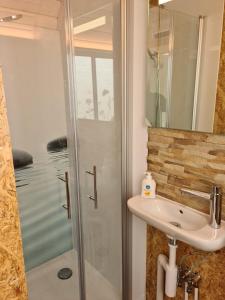ein Bad mit einer Dusche und einem Waschbecken in der Unterkunft La roulotte in Travers