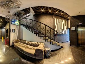 a couch in a lobby with a spiral staircase at Efbet Hotel in Varna City