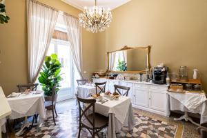 a dining room with two tables and a mirror at xenìa in Siracusa