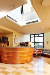 a lobby with a reception counter and a living room at Primhotel in Oderzo