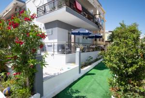 a view of a building with a pool and flowers at Denisa Studios in Sarti