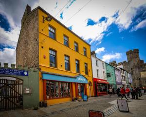 a yellow building on the side of a street at Llety Arall in Caernarfon
