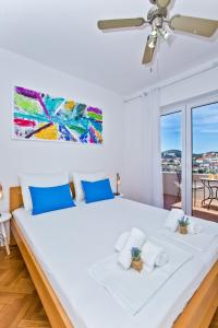 a bedroom with a large white bed with blue pillows at Apartments and Rooms Marija in Hvar