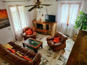 a living room with leather furniture and a fireplace at Casa Valentini in San Giuliano Terme