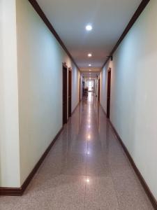 um corredor vazio com paredes brancas e piso em azulejo em SP Residence em Nakhon Phanom