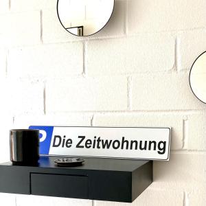 a sign on a wall with a coffee cup on a shelf at Die Zeitwohnung in Hochheim am Main