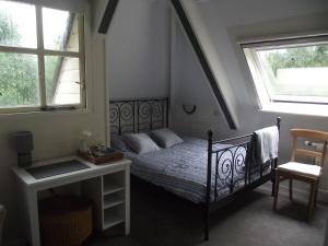 1 dormitorio con 1 cama y 2 ventanas en B&B Landgoed Sonneborghe, en Kollumerzwaag