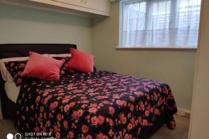 Un dormitorio con una cama con almohadas rojas. en Cozy Entire Bungalow House, en Winchmore Hill