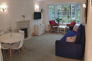 ein Wohnzimmer mit einem blauen Sofa und einem Tisch in der Unterkunft Cozy Entire Bungalow House in Winchmore Hill