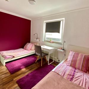 a bedroom with two beds and a desk and a window at Die Zeitwohnung in Hochheim am Main