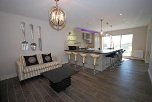 a kitchen and living room with a bar and a couch at Amber Cottage - Luxury Cottage, Hot Tub, Sea Views and Log Burner in Saundersfoot