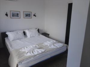 a bed with white sheets and pillows on it at Hotel Mistral in Nesebar