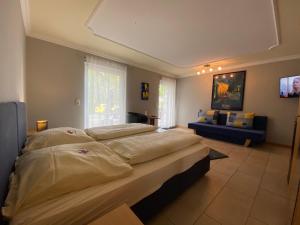 um quarto grande com uma cama grande e um sofá em Gaestehaus Savo em Nürburg