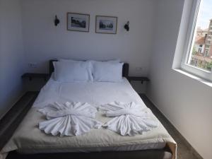 a bed with two pillows on it in a bedroom at Hotel Mistral in Nesebar