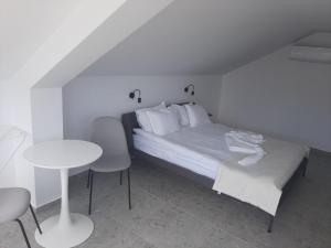 1 dormitorio con 1 cama, mesa y sillas en Hotel Mistral, en Nesebar