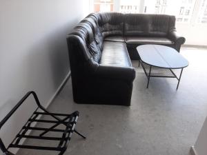 a living room with a leather couch and a table at Hotel Mistral in Nesebar