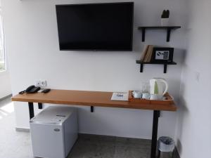 a desk with a flat screen tv on a wall at Hotel Mistral in Nesebar