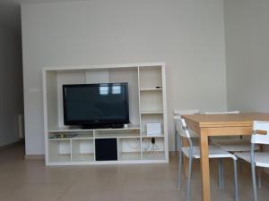 a television on a white entertainment center with a table at UGARTEKO ETXEA in Llodio