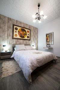 a bedroom with a large bed and a painting on the wall at APARTAMENTO LA VEGUILLA in Alhama de Aragón